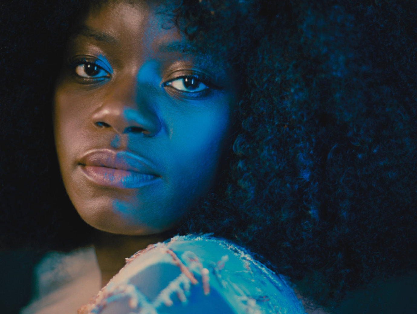 Close up shot of young woman, looking over her shoulder, making a pensive expression