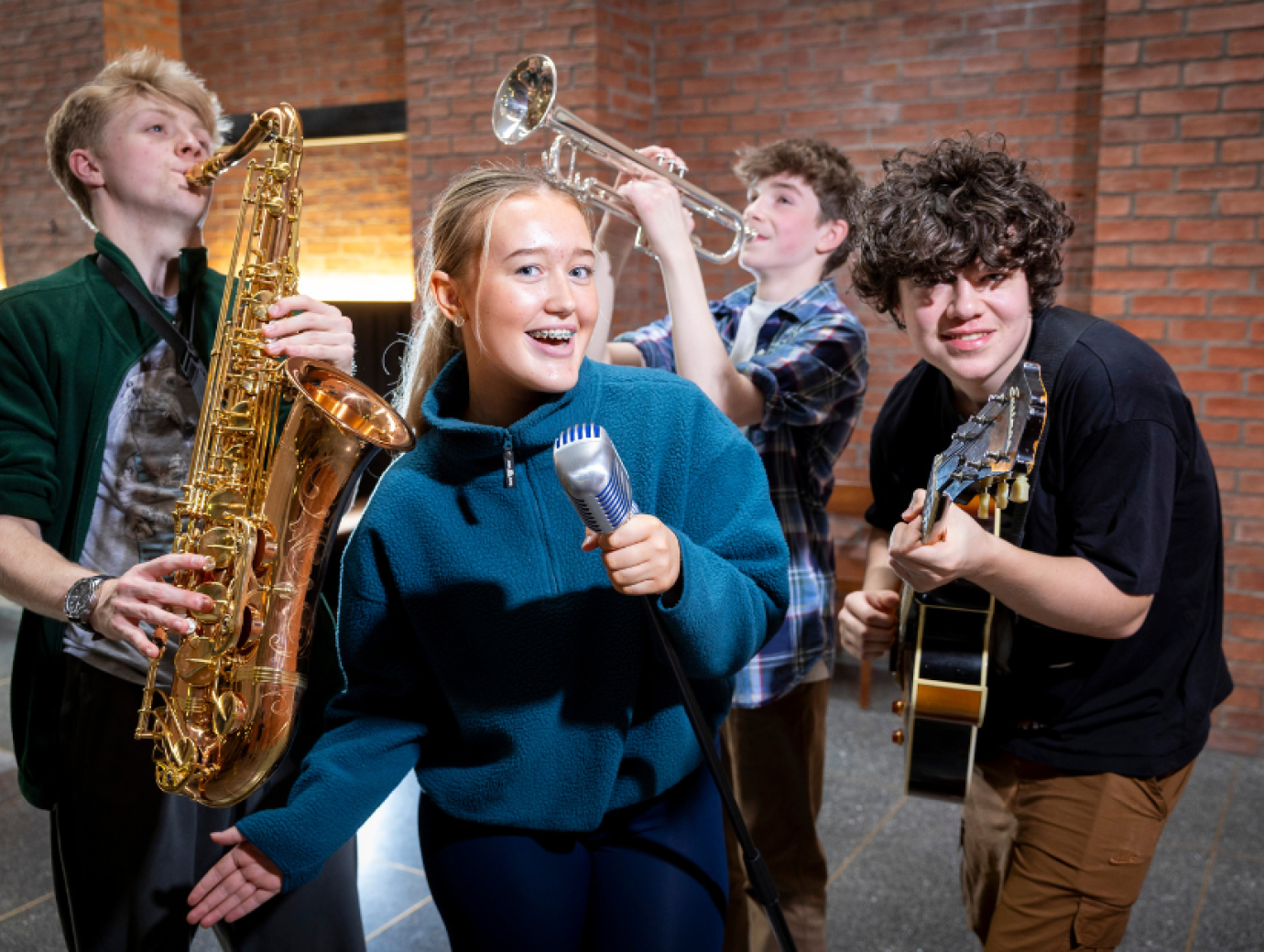 A group of 4 young people playing jazz instruments and singing