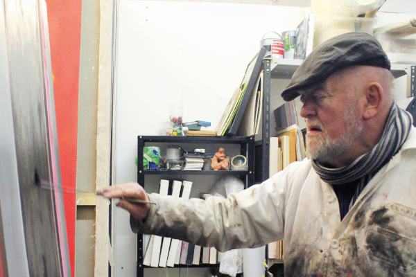 A photo of Ray Duncan, painting on a canvas.