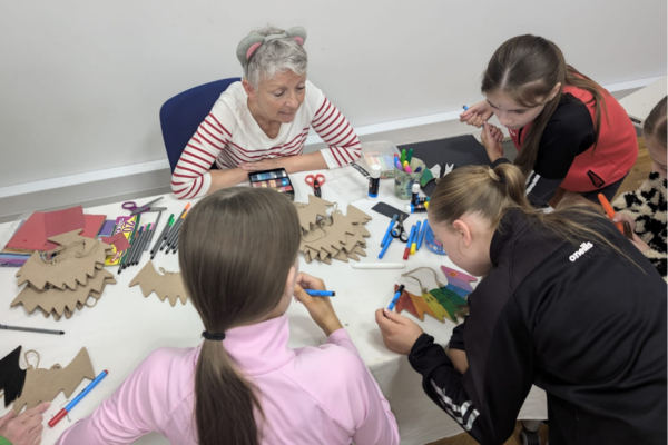 Children gathered around a table taking part in arts and crafts