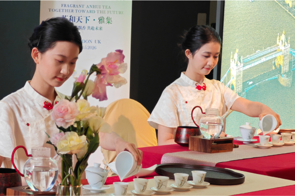 two women siting at a table pouring tea