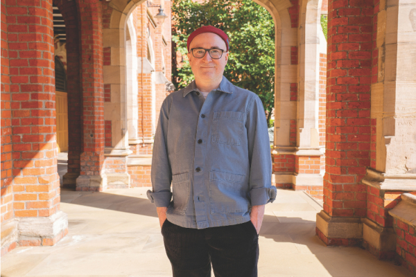 A man standing looking at the camera with his hands in his pockets