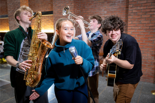 A group of 4 young people playing jazz instruments and singing