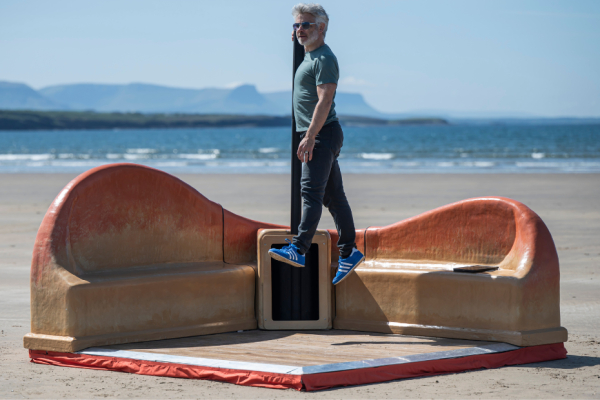 A man jumps in the air on the beach as part of the Dance Corner project.