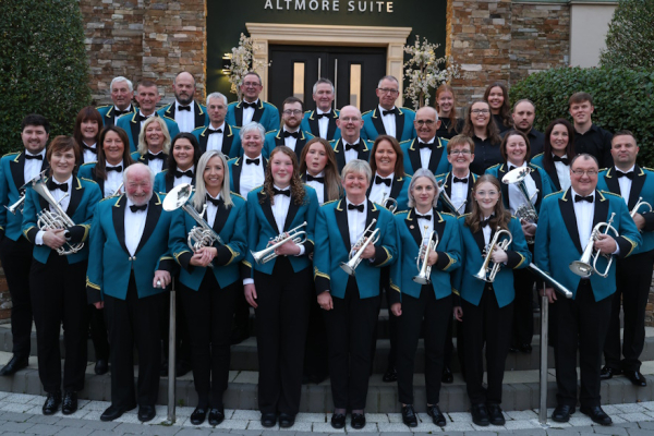 Image of band in deep green uniforms with instruments in hand