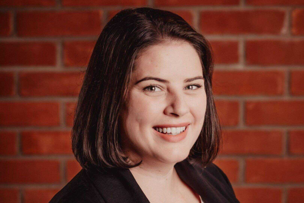 Photo of woman with dark hair in front of a wall