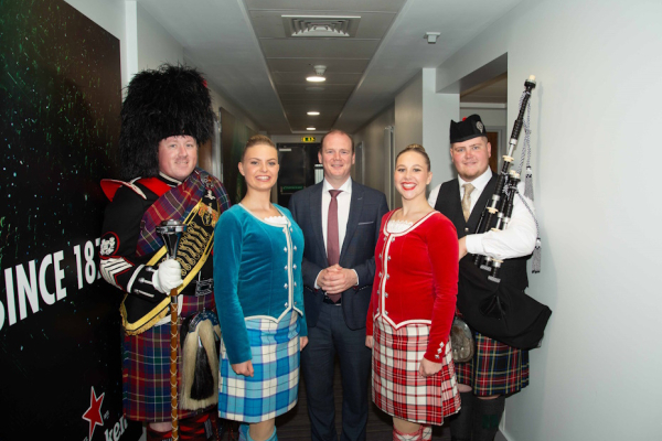 Picture of the Minister pictured with band members, with instruments and in traditional scottish kilts