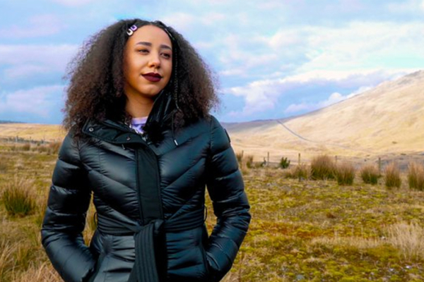 Musician and broadcaster Gemma Bradley standing in a rural location with a mountain in the background.