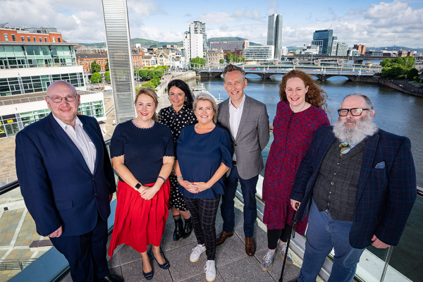 Group of people smiling on the balcony at the ICC in Belfast.