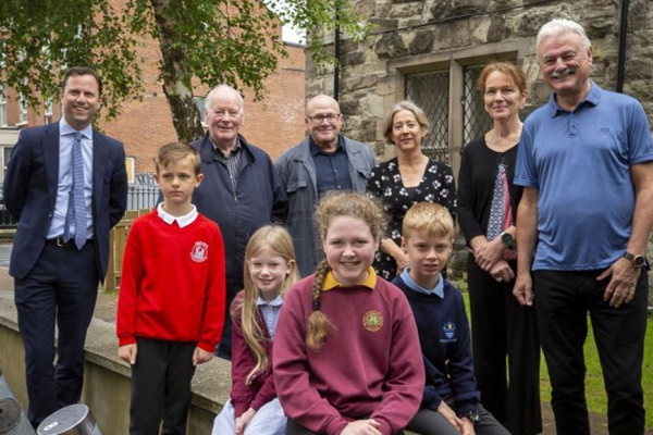 Group of adults and young people smiling outside The Duncairn Arts Centre in Belfast