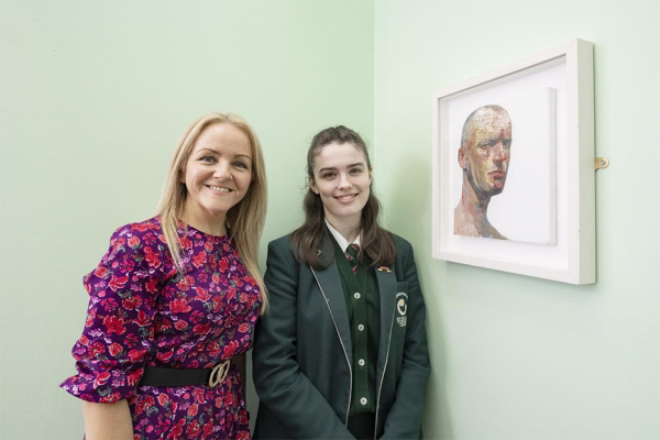 St Cecilia’s College Head of Art and Art student smiling beside a painting by artist Michael Bell.