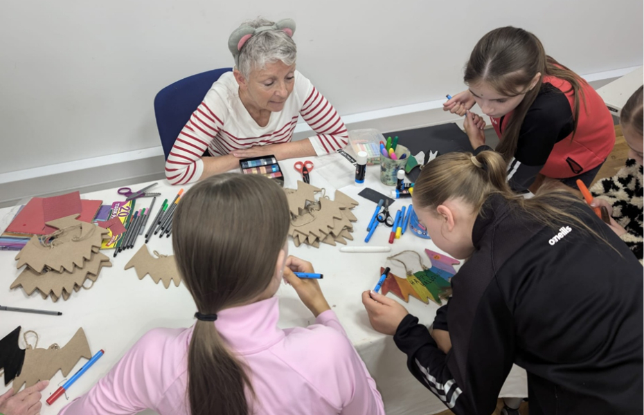 Children gathered around a table taking part in arts and crafts