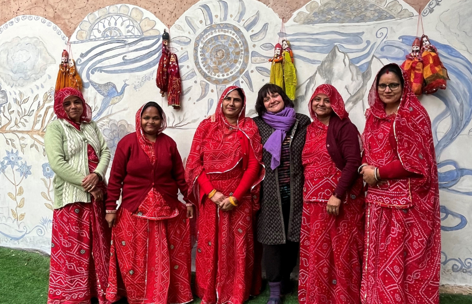 Women standing in front of a wall mural in India