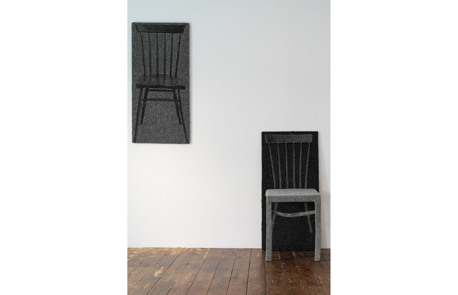 Two black and grey wall mounted panels of a chair created using Irish Wool.