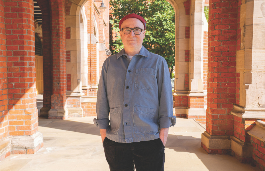 A man standing looking at the camera with his hands in his pockets