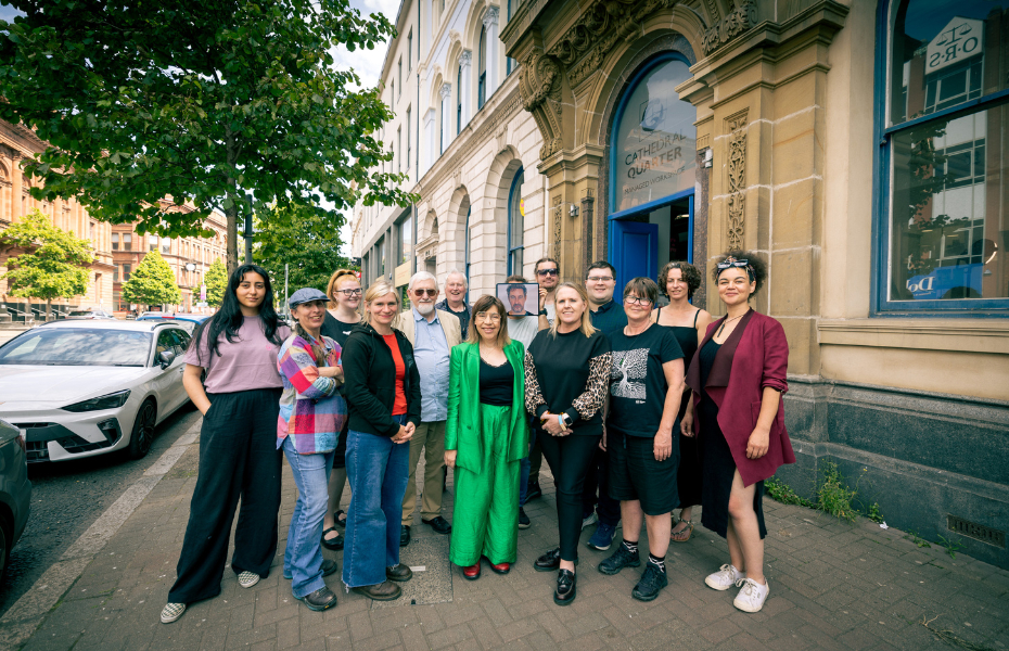 A group of people standing facing the camera smiling outside the University of Atypical's office in Belfast.
