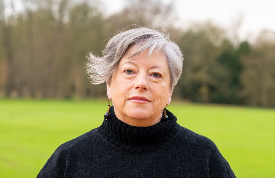 Vona Groarke, poses for a photograph. They are wearing a black polo neck jumper and have short hair with a sweeping fringe.