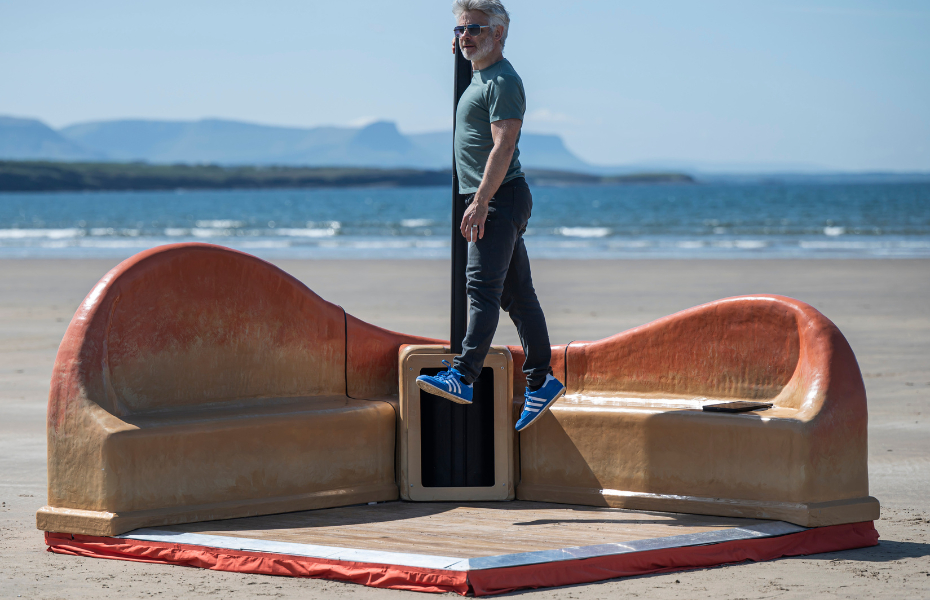 A man jumps in the air on the beach as part of the Dance Corner project.