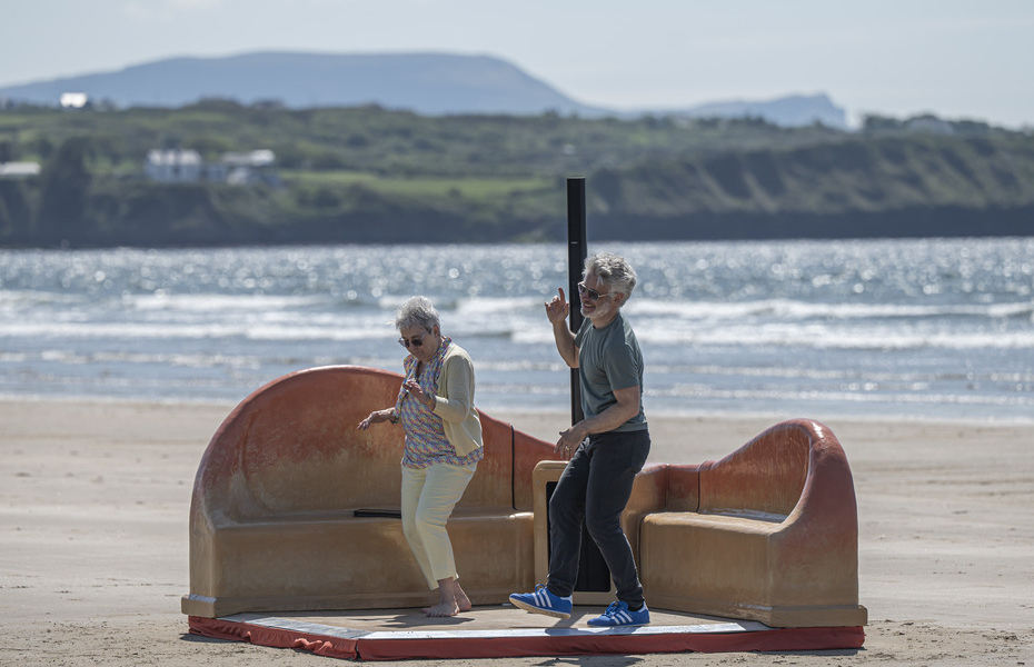 A man and a woman dancing on the beach.