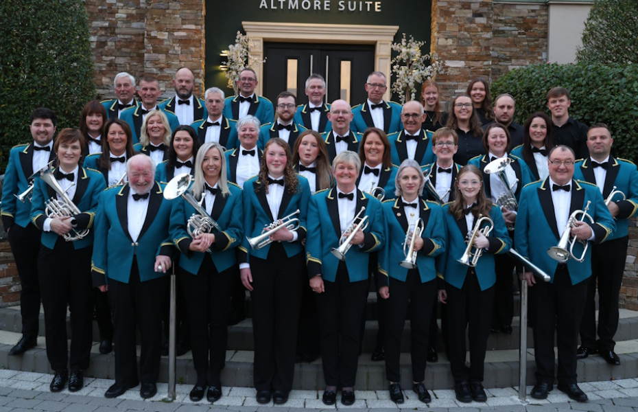 Image of band in deep green uniforms with instruments in hand