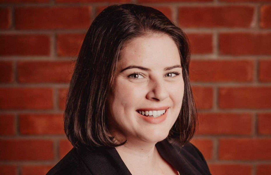 Photo of woman with dark hair in front of a wall