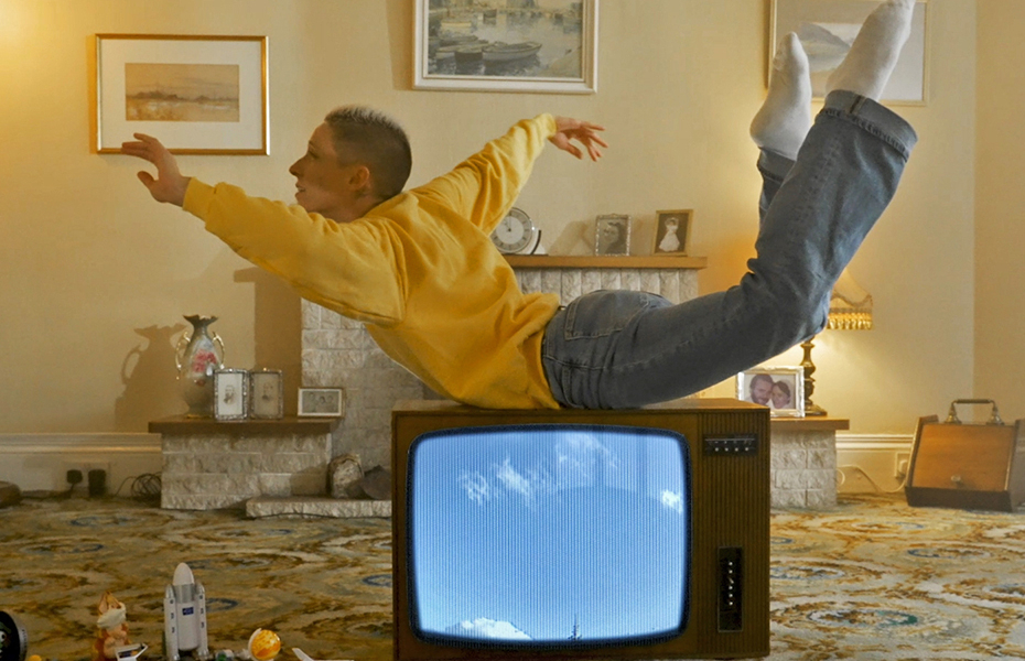 Dancer performing on top of an analogue television.