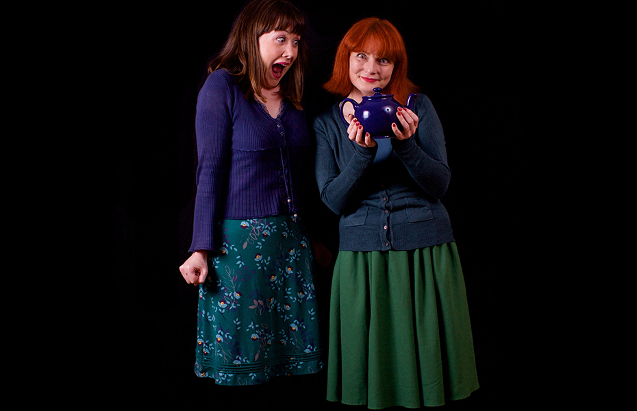 Gemma Walker-Farren and Sorcha Shanahan from the MakeyUppers standing against a black background. One female is holding a blue teapot.
