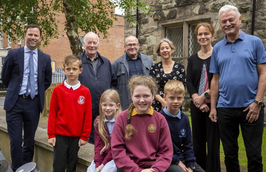Group of adults and young people smiling outside The Duncairn Arts Centre in Belfast