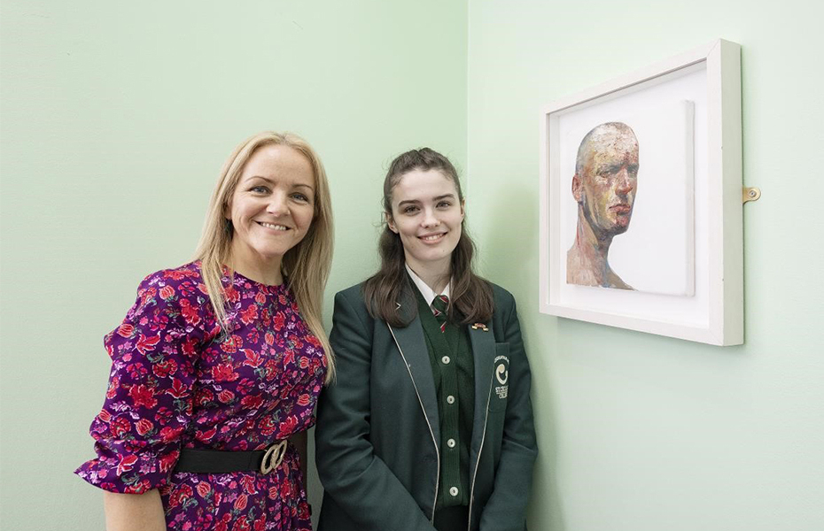 St Cecilia’s College Head of Art and Art student smiling beside a painting by artist Michael Bell.