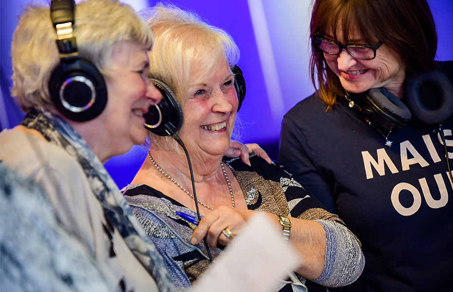 Group of females in a recording studio wearing music headphones.